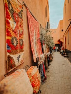 Explore a lively Moroccan alley adorned with vibrant carpets in Marrakesh.